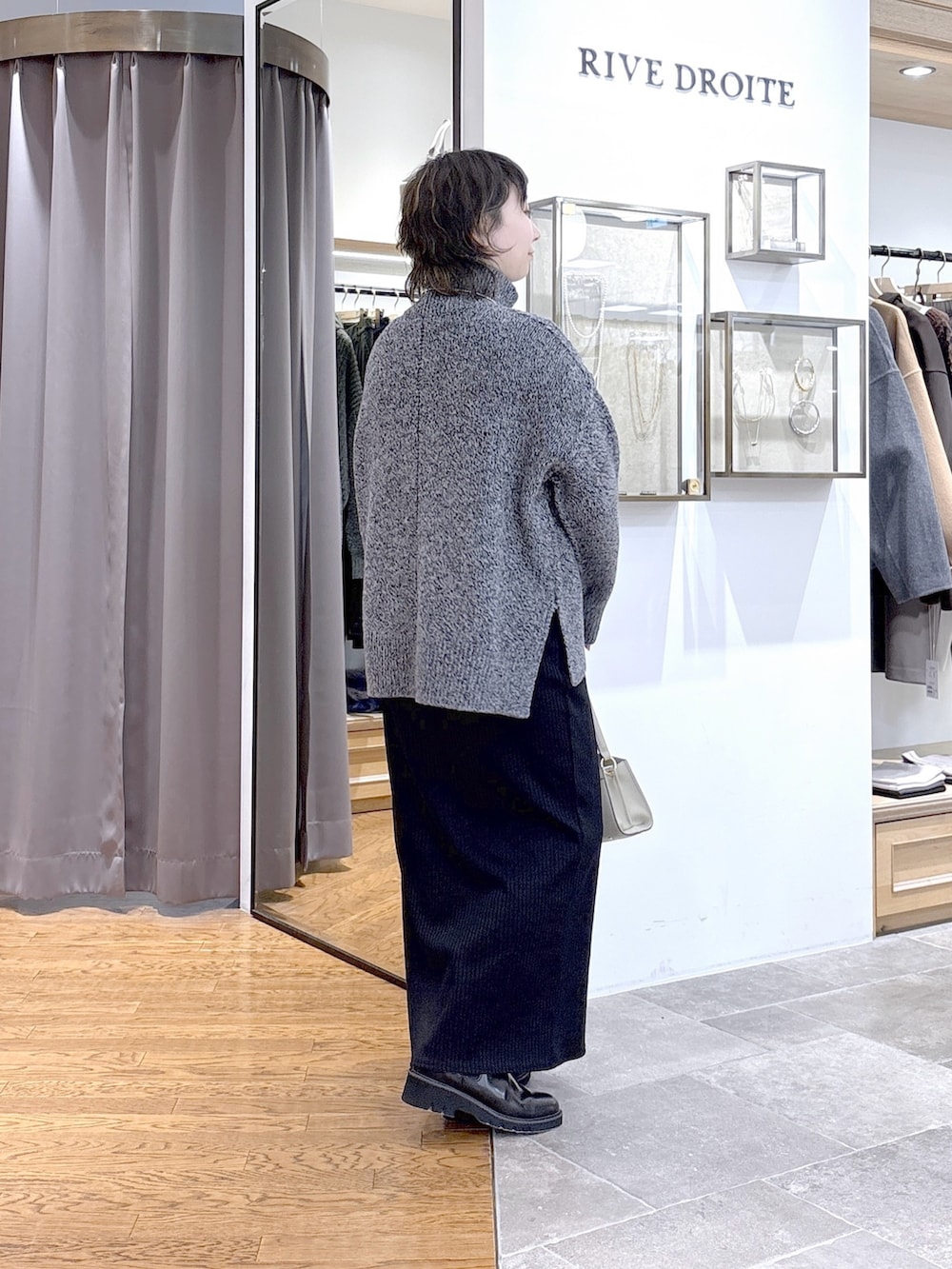 グレー系のニット/セーター、ベージュ系のハンドバッグ、グレー系のその他アウターを着用したレディースの秋コーディネートの5枚目の写真