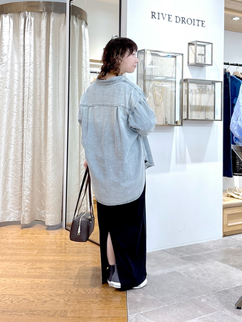 ブルー系のシャツ/ブラウス、ブラック系のワンピース、ブラウン系のショルダーバッグを着用したレディースの夏コーディネートの4枚目の写真