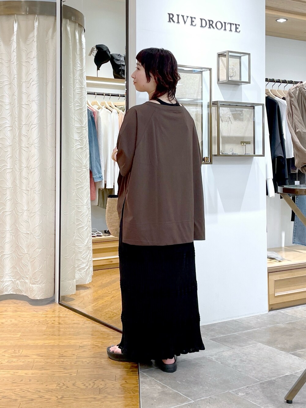 ブラウン系のTシャツ/カットソー、ブラック系のスカート、ゴールド系のネックレスを着用したレディースの春コーディネートの3枚目の写真