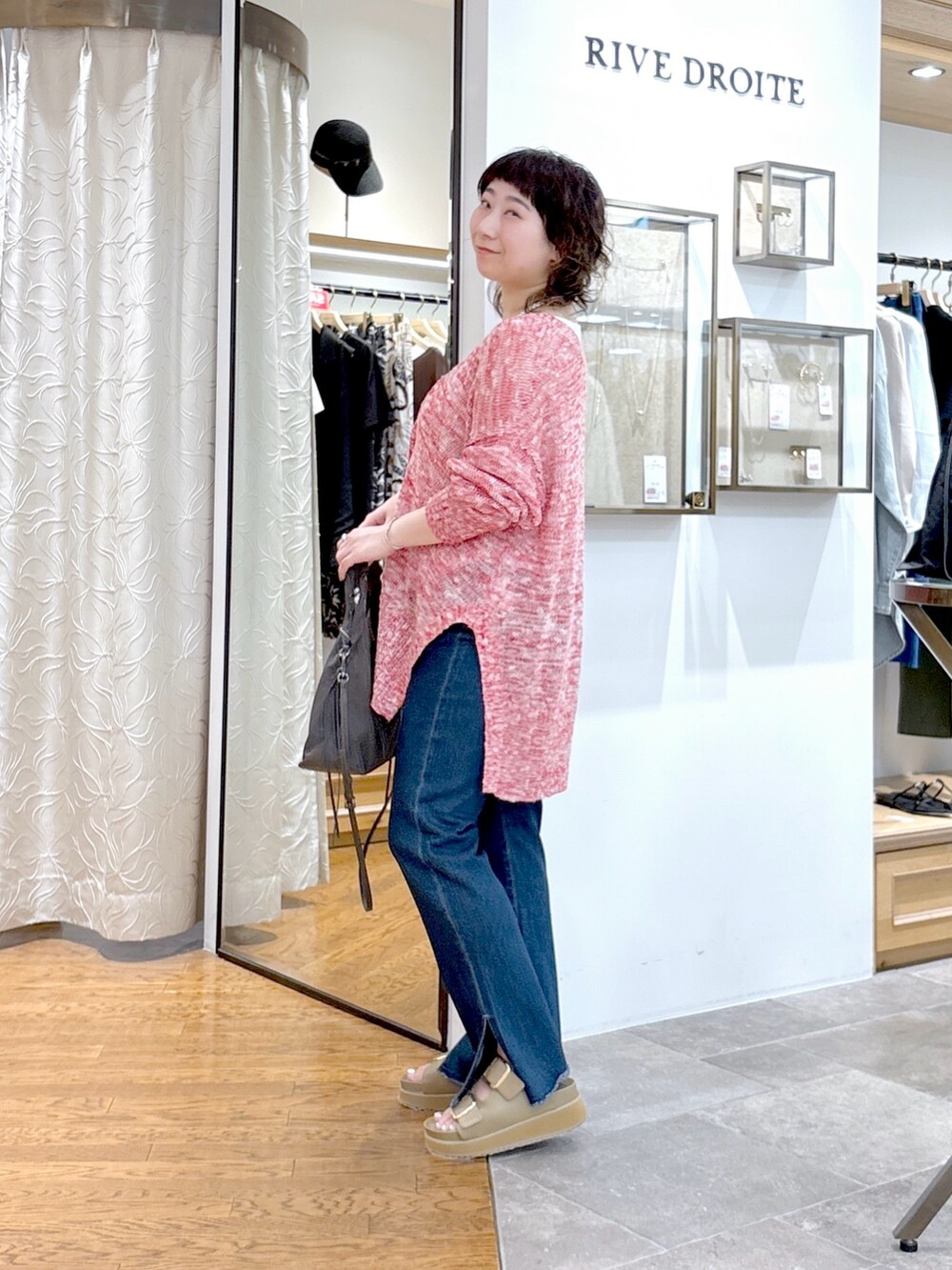 ホワイト系のタンクトップ、レッド系のカーディガン/ボレロ、グリーン系のハンドバッグを着用したレディースの夏コーディネートの2枚目の写真