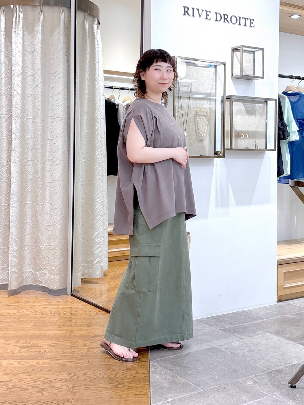 グレー系のTシャツ/カットソー、グリーン系のスカート、ブラウン系のハンドバッグを着用したレディースの夏コーディネートの5枚目の写真