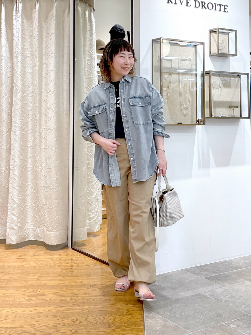 グレー系のTシャツ/カットソー、ホワイト系のハンドバッグ、ブルー系のシャツ/ブラウスを着用したレディースの春コーディネートの3枚目の写真