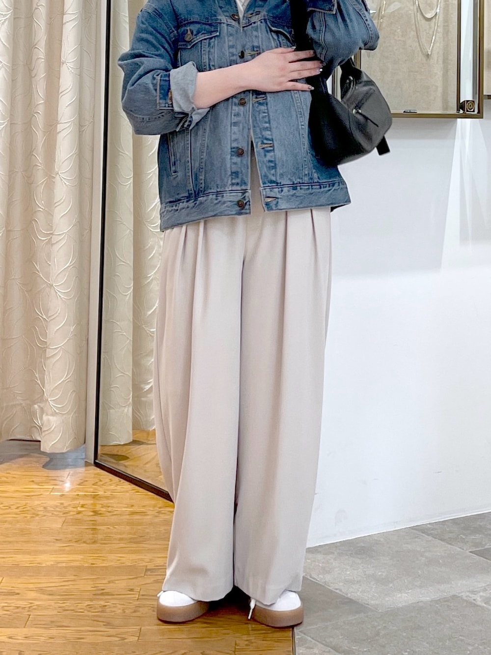 ホワイト系のTシャツ/カットソー、ブラック系のハンドバッグ、ブルー系のデニムジャケットを着用したレディースの春コーディネートの4枚目の写真