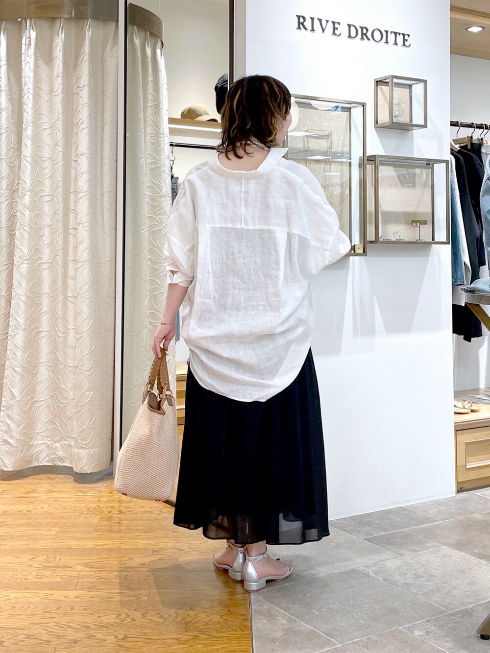 ブラック系のタンクトップ、ホワイト系のシャツ/ブラウス、ブラック系のスカートを着用したレディースの春コーディネートの3枚目の写真