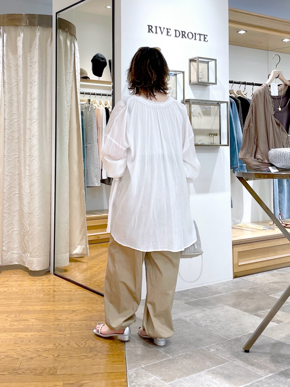 ベージュ系のタンクトップ、ホワイト系のシャツ/ブラウス、ホワイト系のハンドバッグを着用したレディースの春コーディネートの6枚目の写真