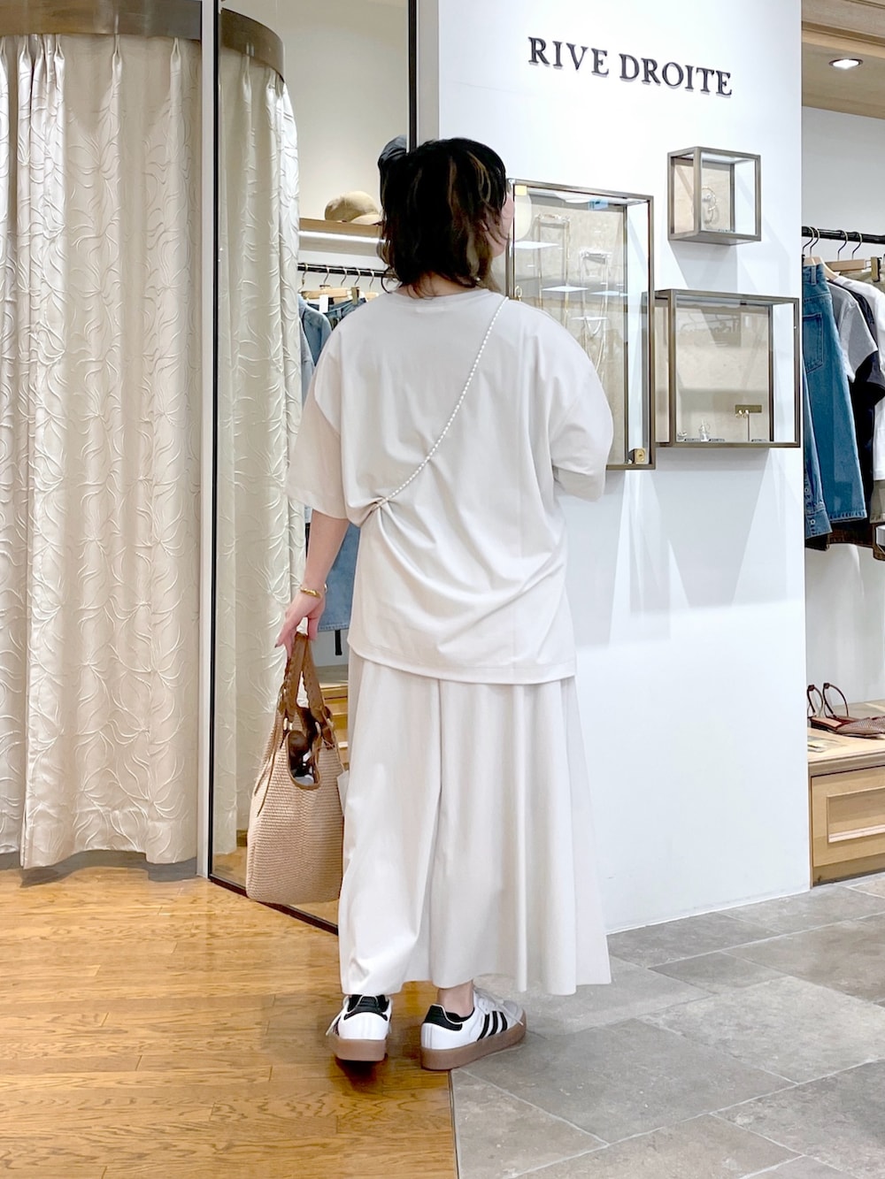 ホワイト系のTシャツ/カットソー、ブラウン系のトートバッグ、ホワイト系のスカートを着用したレディースの春コーディネートの3枚目の写真