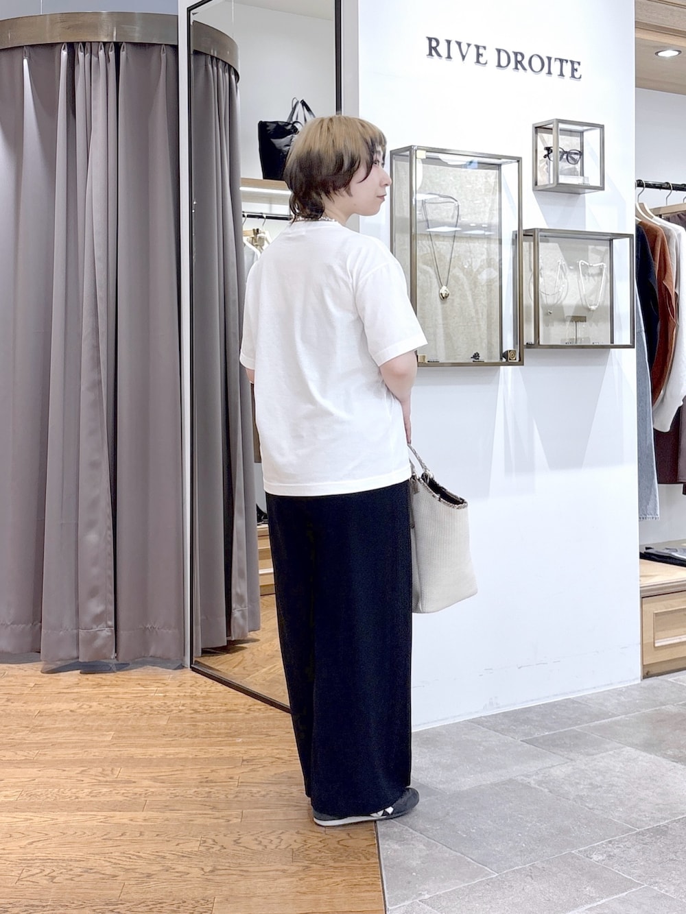 ホワイト系のTシャツ/カットソー、ベージュ系のハンドバッグ、ブラック系のその他パンツを着用したレディースの夏コーディネートの3枚目の写真