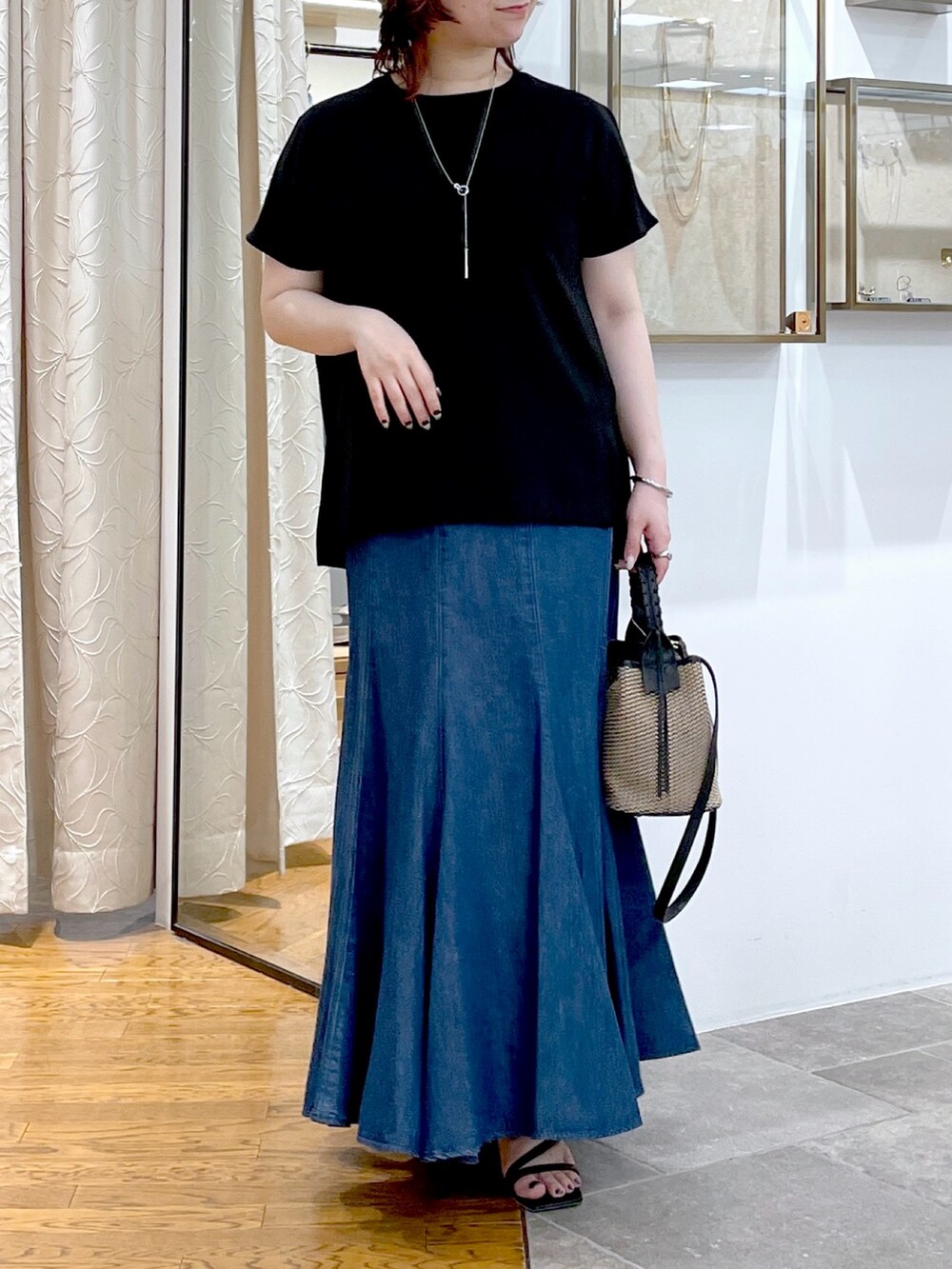 ブラック系のシャツ/ブラウス、ブルー系のスカート、ブラック系のハンドバッグを着用したレディースの春コーディネートの4枚目の写真