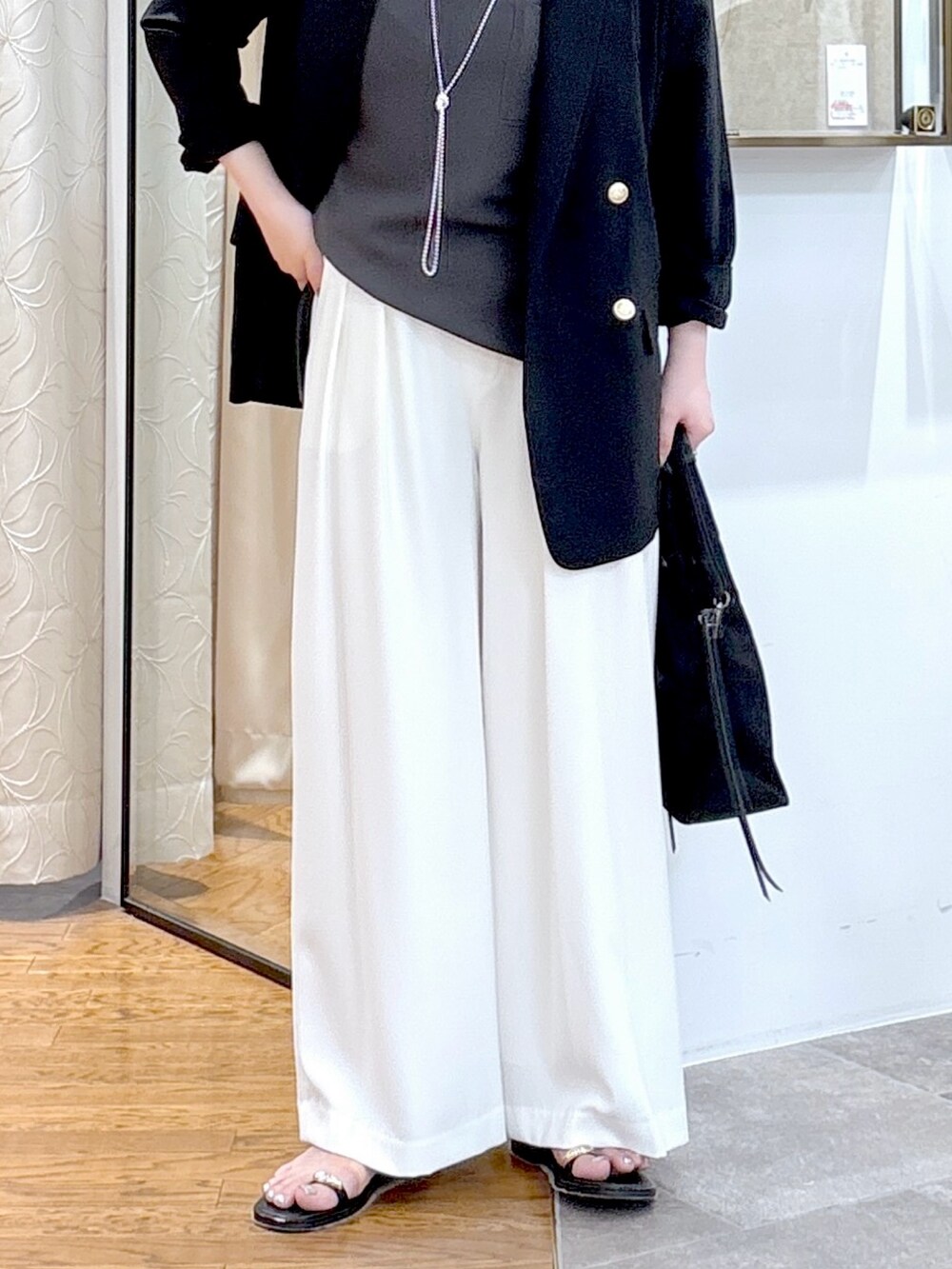 グレー系のシャツ/ブラウス、ブラック系のテーラードジャケット、ブラック系のハンドバッグを着用したレディースの夏コーディネートの4枚目の写真