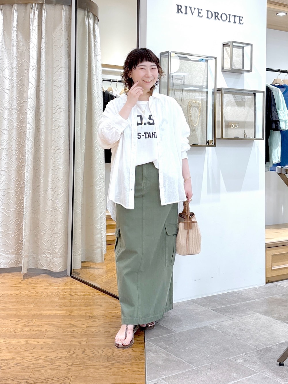 ブラウン系のハンドバッグ、ホワイト系のTシャツ/カットソー、ホワイト系のシャツ/ブラウスを着用したレディースの夏コーディネートの2枚目の写真