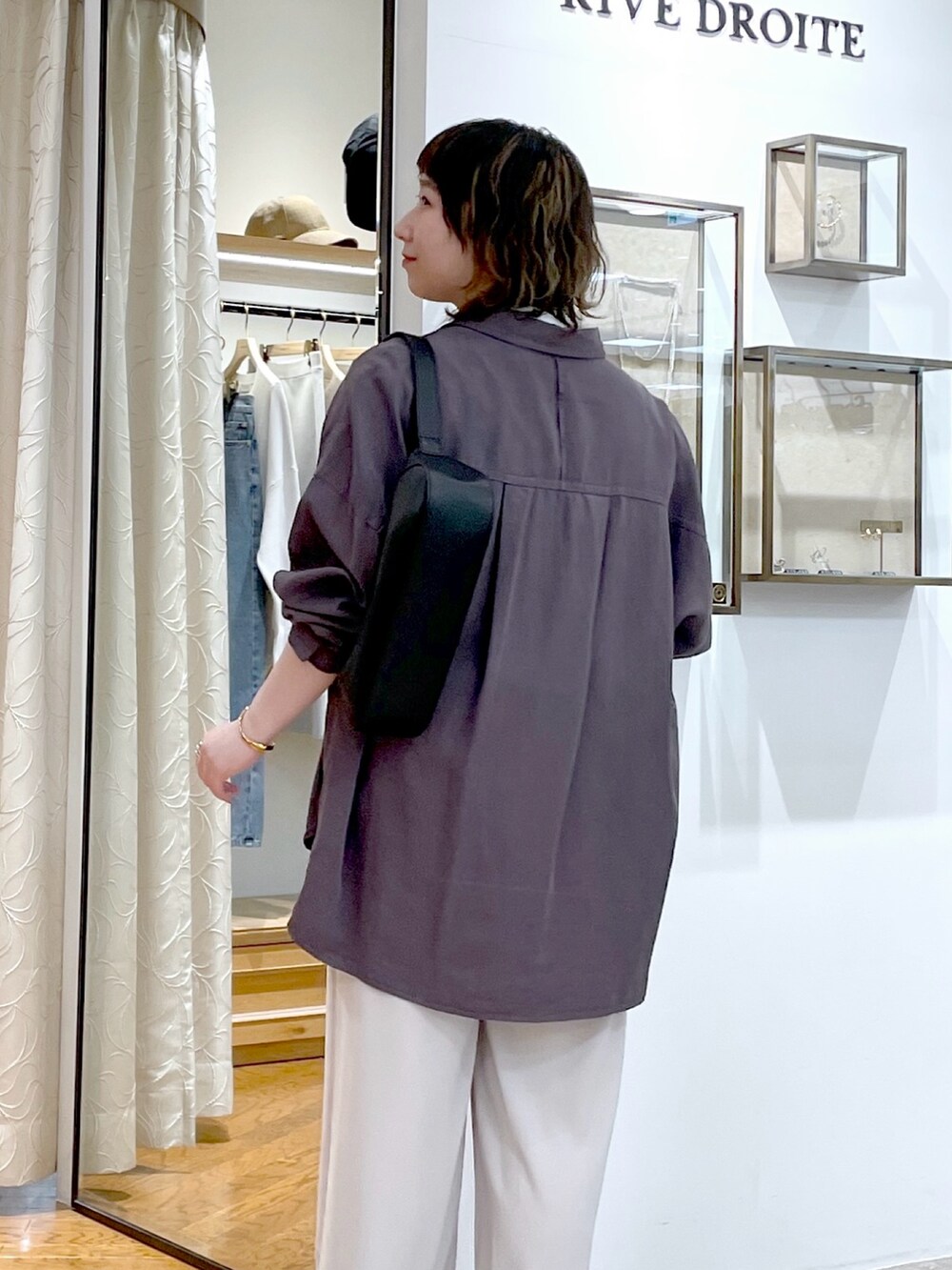 グレー系のスラックス、グレー系のシャツ/ブラウス、ホワイト系のTシャツ/カットソーを着用したレディースの春コーディネートの3枚目の写真