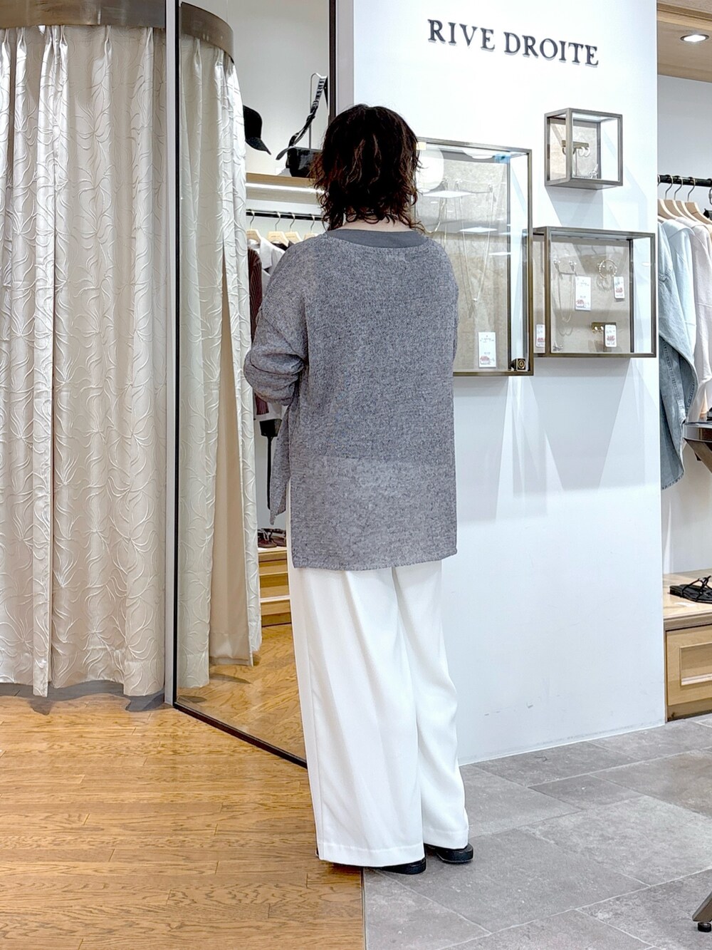 グレー系のニット/セーター、グレー系のタンクトップ、ブラック系のハンドバッグを着用したレディースの夏コーディネートの3枚目の写真