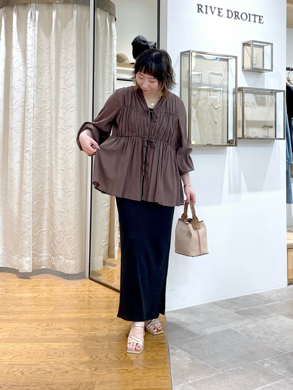 ブラウン系のシャツ/ブラウス、ブラウン系のハンドバッグ、ブラック系のワンピースを着用したレディースの春コーディネートの5枚目の写真