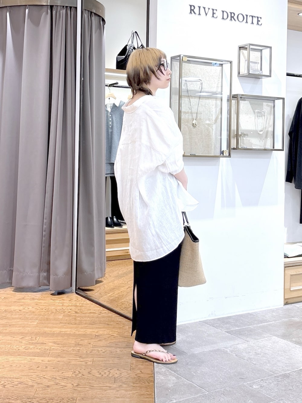 ブラック系のハンドバッグ、ブラック系のスカート、ホワイト系のシャツ/ブラウスを着用したレディースの夏コーディネートの2枚目の写真