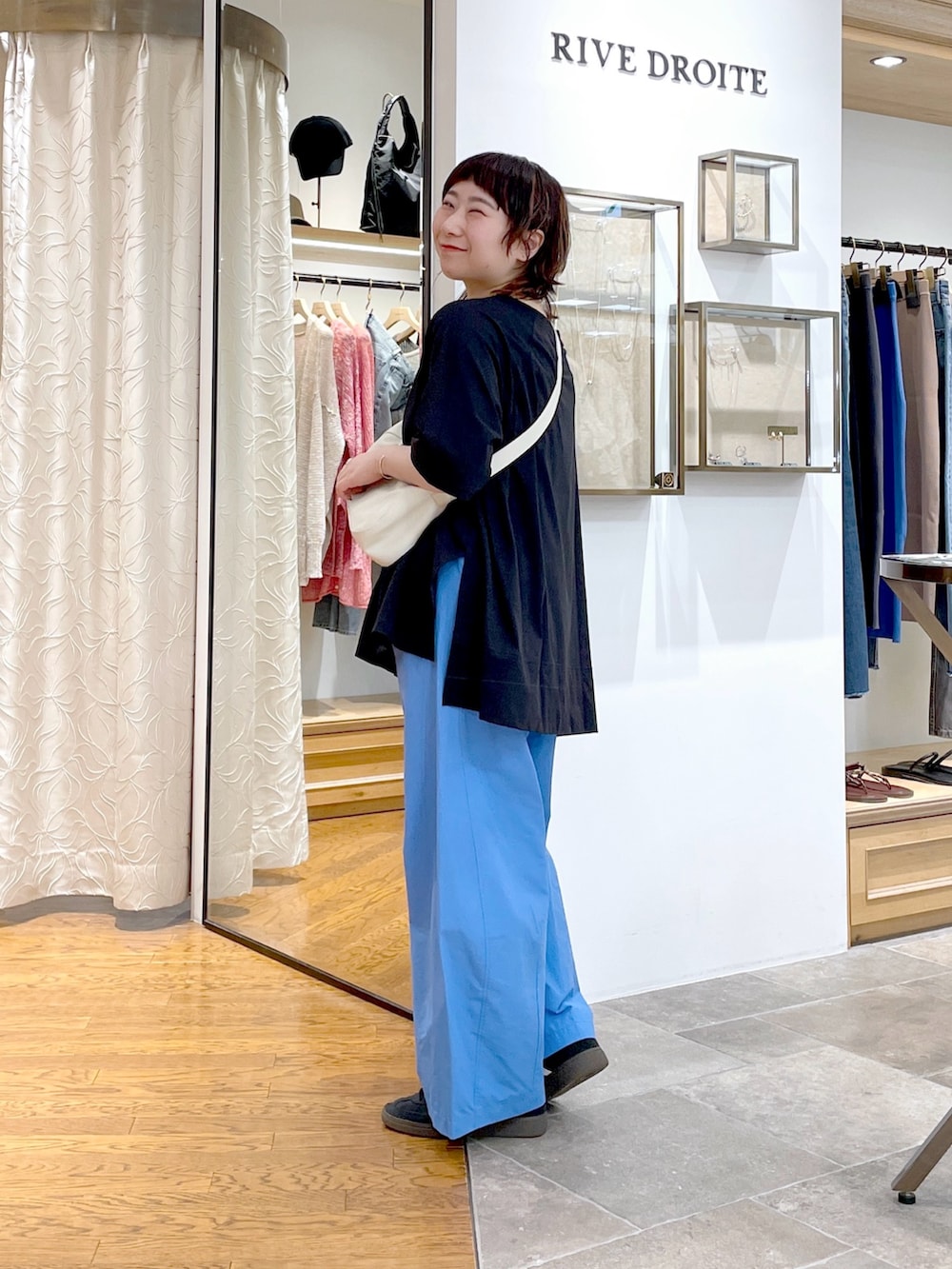 ホワイト系のハンドバッグ、ブラック系のTシャツ/カットソー、ブルー系のその他パンツを着用したレディースの夏コーディネートの2枚目の写真