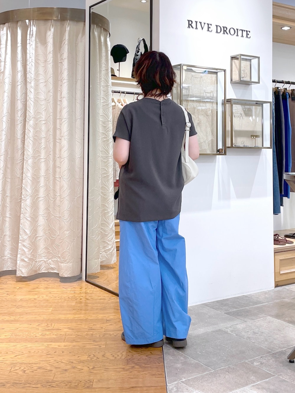 ホワイト系のハンドバッグ、グレー系のシャツ/ブラウス、ブルー系のその他パンツを着用したレディースの夏コーディネートの3枚目の写真