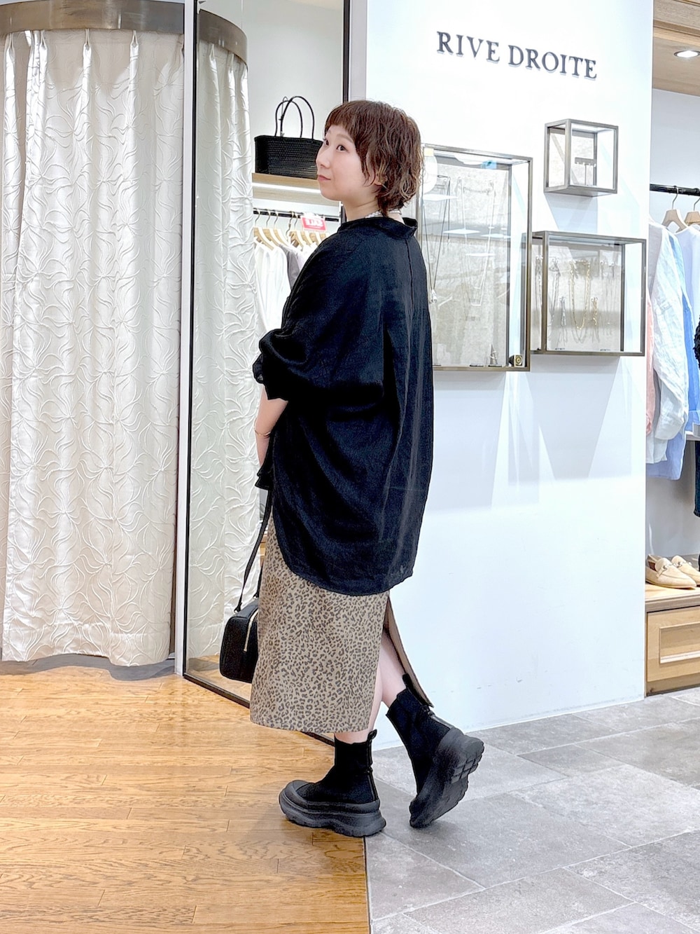 ブラック系のシャツ/ブラウス、ブラウン系のスカート、ブラック系のショルダーバッグを着用したレディースの夏コーディネートの2枚目の写真