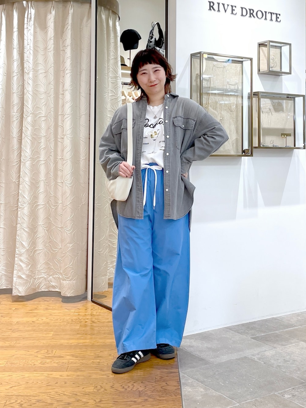 ホワイト系のTシャツ/カットソー、ホワイト系のハンドバッグ、グレー系のシャツ/ブラウスを着用したレディースの夏コーディネートの2枚目の写真