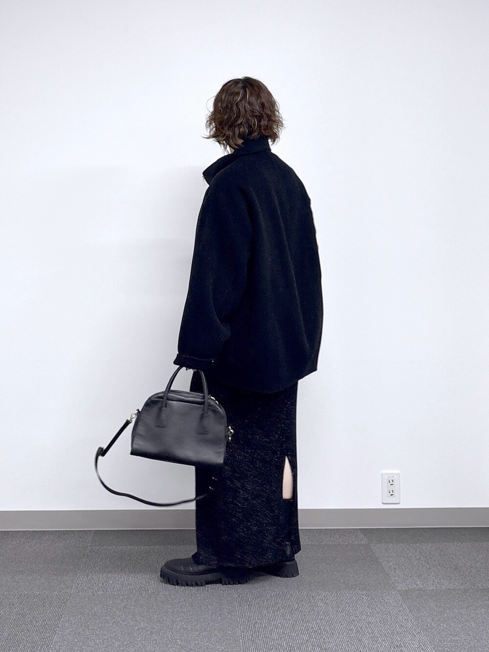 ブラック系のその他アウター、ブラック系のスカート、ブラック系のニット/セーターを着用したレディースの秋コーディネートの2枚目の写真