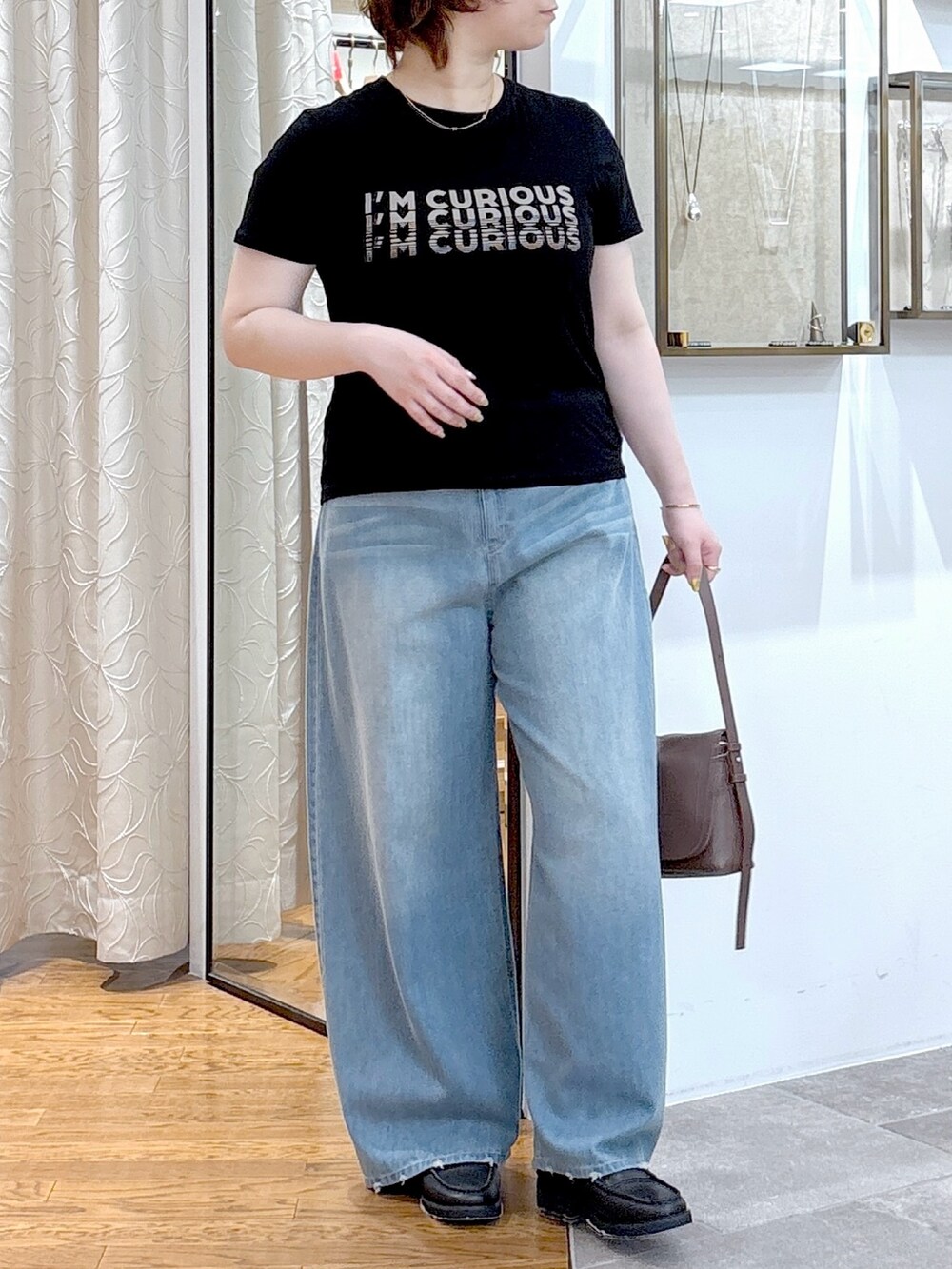 ブラック系のTシャツ/カットソー、ブラウン系のショルダーバッグ、ブルー系のデニムパンツを着用したレディースの夏コーディネートの3枚目の写真