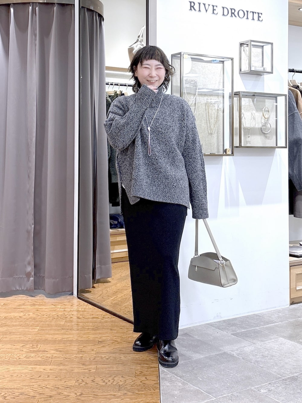 グレー系のニット/セーター、ベージュ系のハンドバッグ、グレー系のその他アウターを着用したレディースの秋コーディネートの4枚目の写真