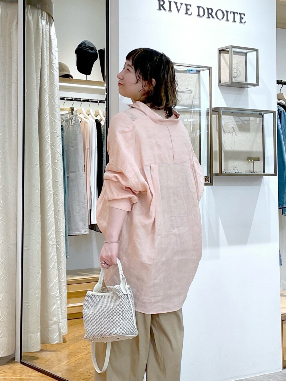 ピンク系のシャツ/ブラウス、ホワイト系のハンドバッグ、ベージュ系のその他パンツを着用したレディースの春コーディネートの6枚目の写真