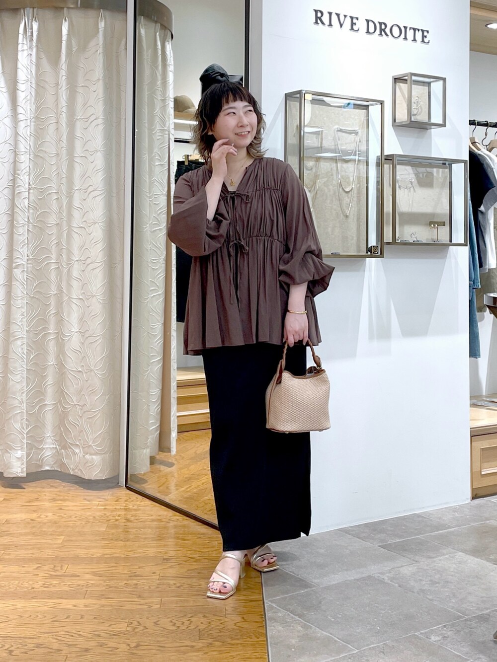 ブラウン系のシャツ/ブラウス、ブラウン系のハンドバッグ、ブラック系のワンピースを着用したレディースの春コーディネートの6枚目の写真