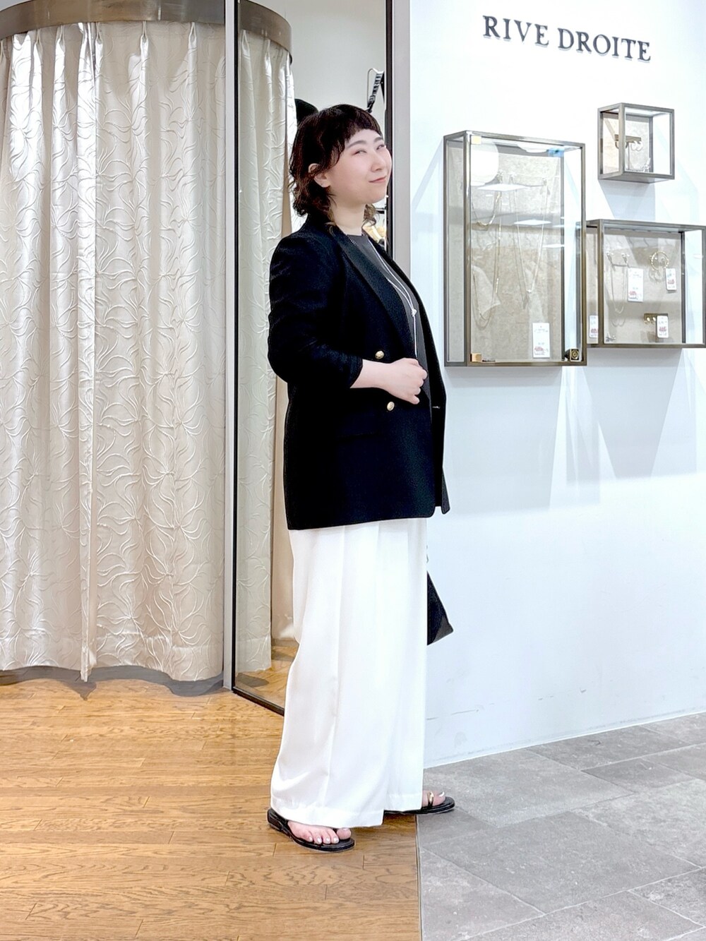 グレー系のシャツ/ブラウス、ブラック系のテーラードジャケット、ブラック系のハンドバッグを着用したレディースの夏コーディネートの2枚目の写真