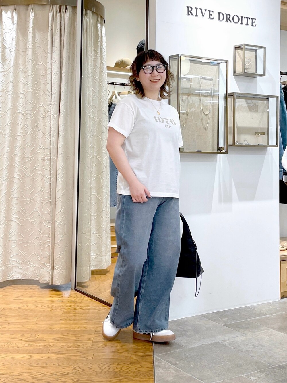 ホワイト系のTシャツ/カットソー、ブラック系のハンドバッグ、ブルー系のデニムパンツを着用したレディースの春コーディネートの3枚目の写真