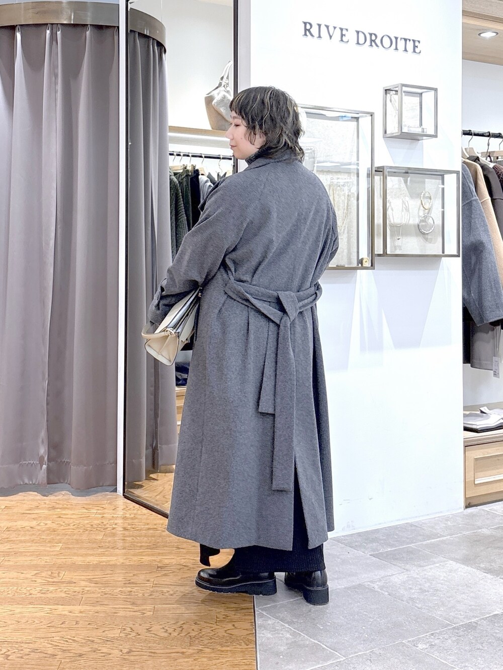 グレー系のニット/セーター、ベージュ系のハンドバッグ、グレー系のその他アウターを着用したレディースの秋コーディネートの3枚目の写真