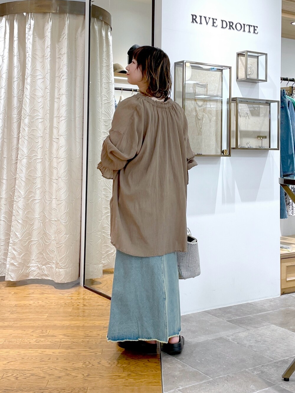 ブラウン系のキャミソール、ブラウン系のシャツ/ブラウス、ブルー系のデニムスカートを着用したレディースの春コーディネートの4枚目の写真