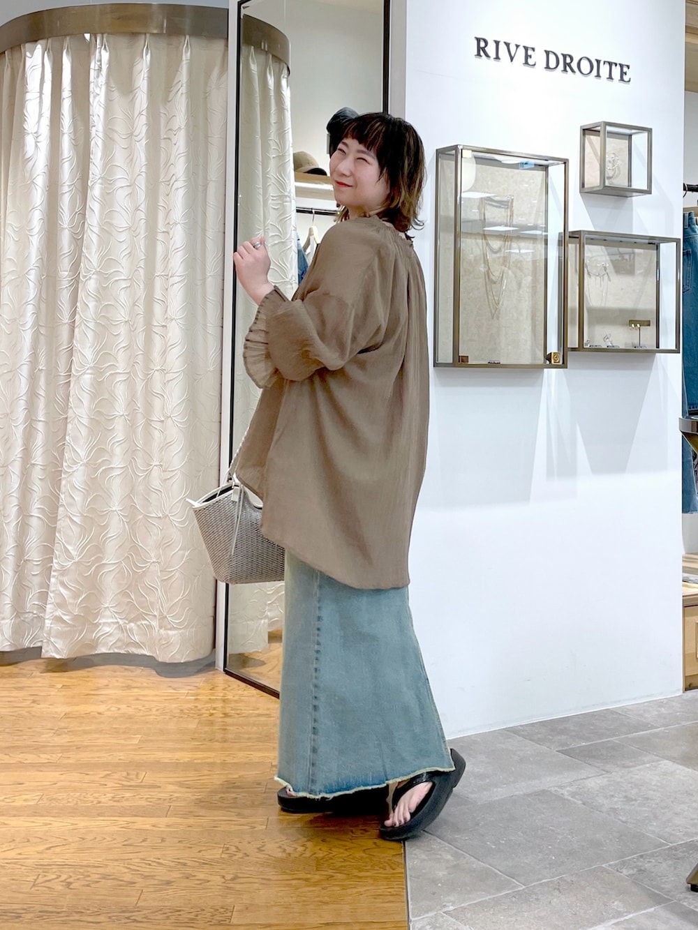 ブラウン系のキャミソール、ブラウン系のシャツ/ブラウス、ブルー系のデニムスカートを着用したレディースの春コーディネートの3枚目の写真