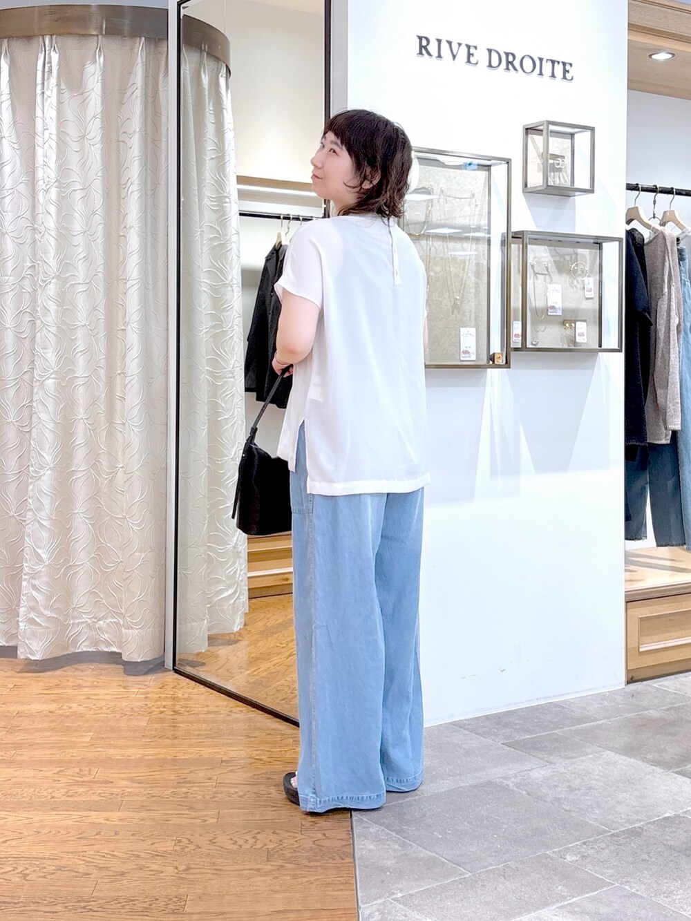 グレー系のシャツ/ブラウス、ブラック系のハンドバッグ、ブルー系のその他パンツを着用したレディースの夏コーディネートの2枚目の写真