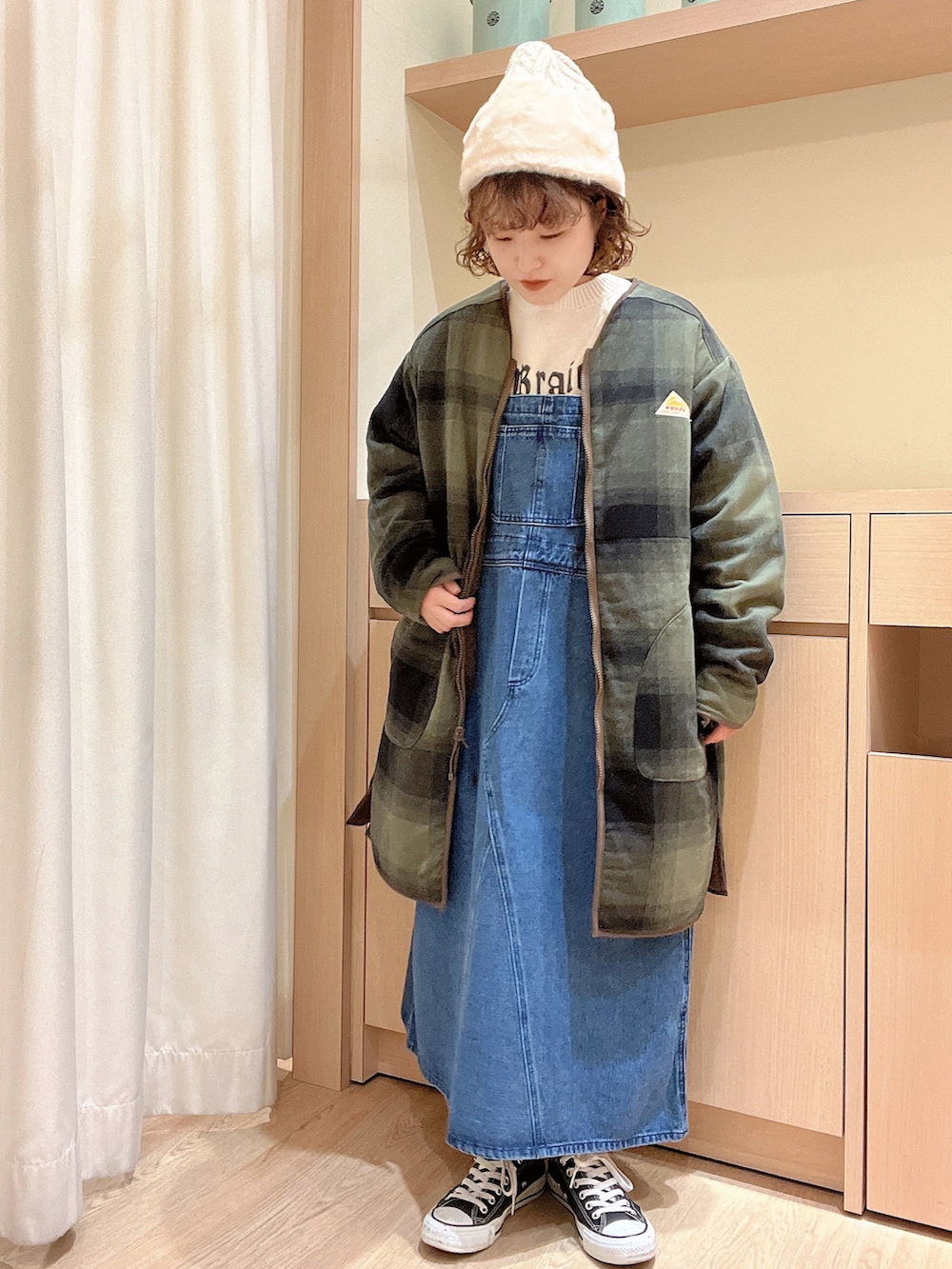 ホワイト系のニット/セーター、ブルー系のジャンパースカート、グリーン系のその他アウターを着用したレディースの秋コーディネートの2枚目の写真