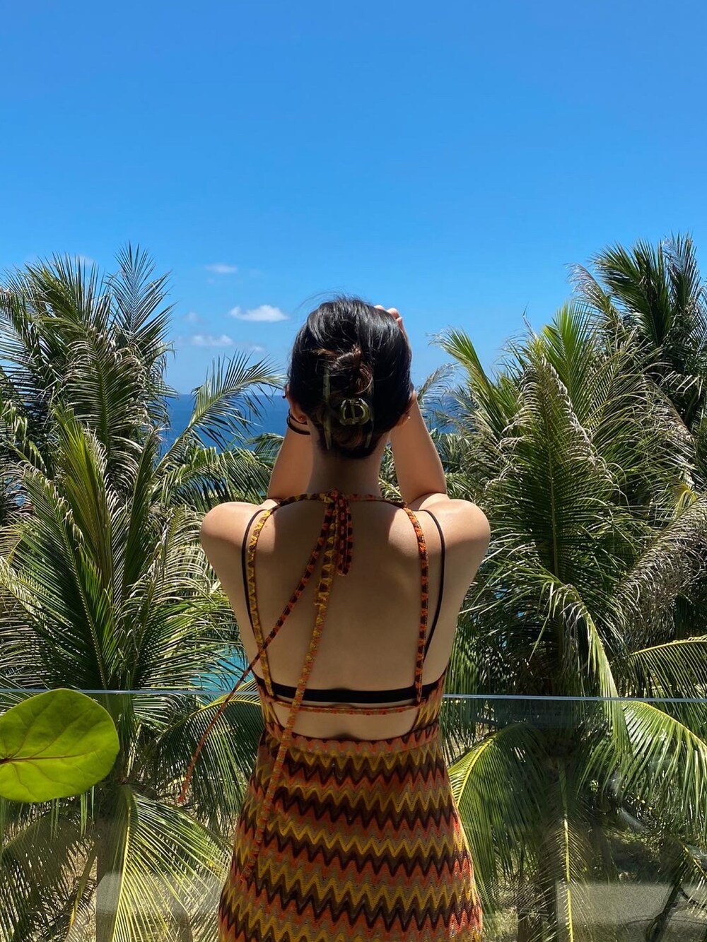 オレンジ系のワンピースを着用したレディースの夏コーディネートの2枚目の写真