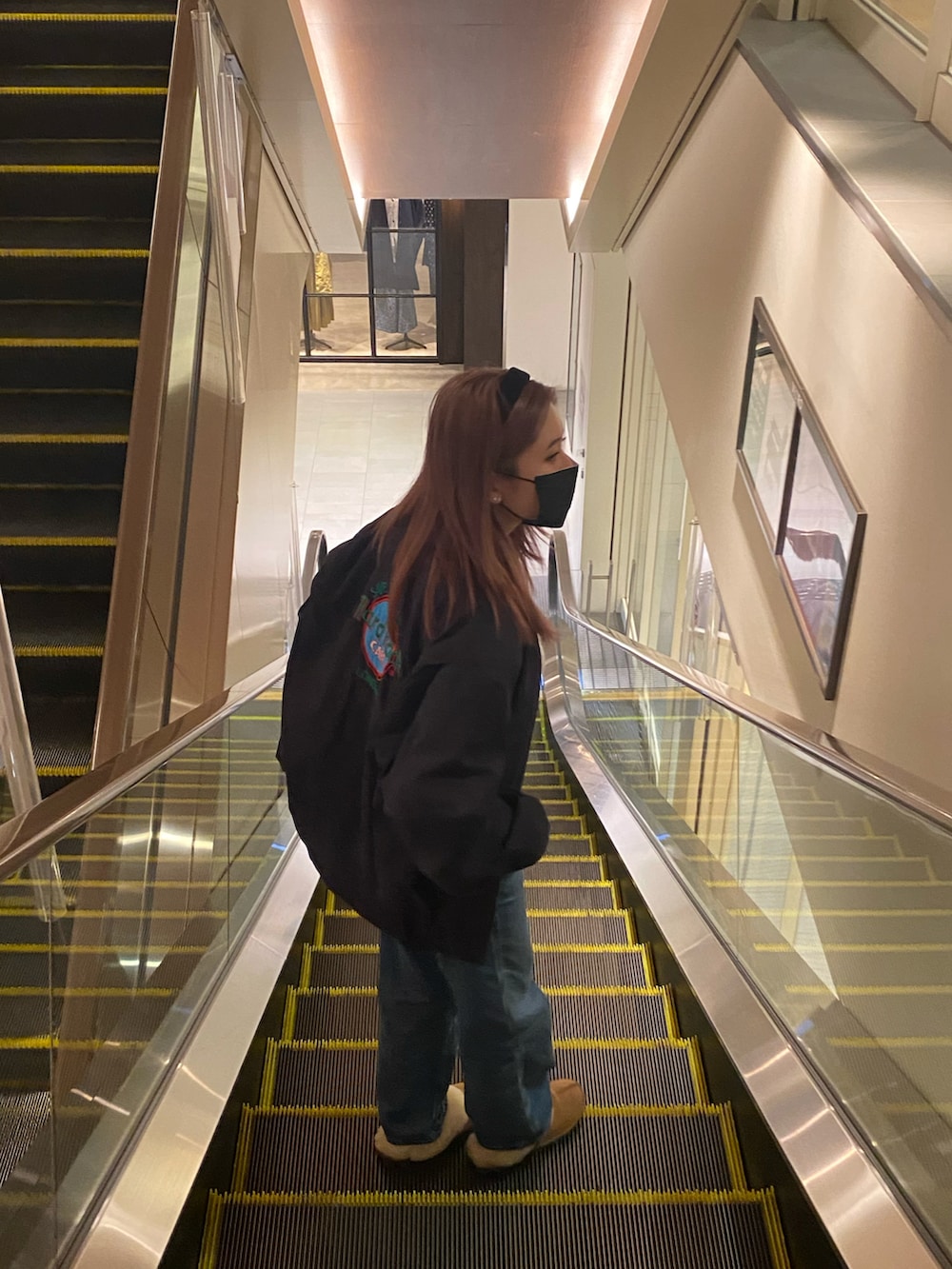 ブラウン系のスリッポン、ブラック系のショルダーバッグ、ブルー系のデニムパンツを着用したレディースの秋コーディネートの3枚目の写真