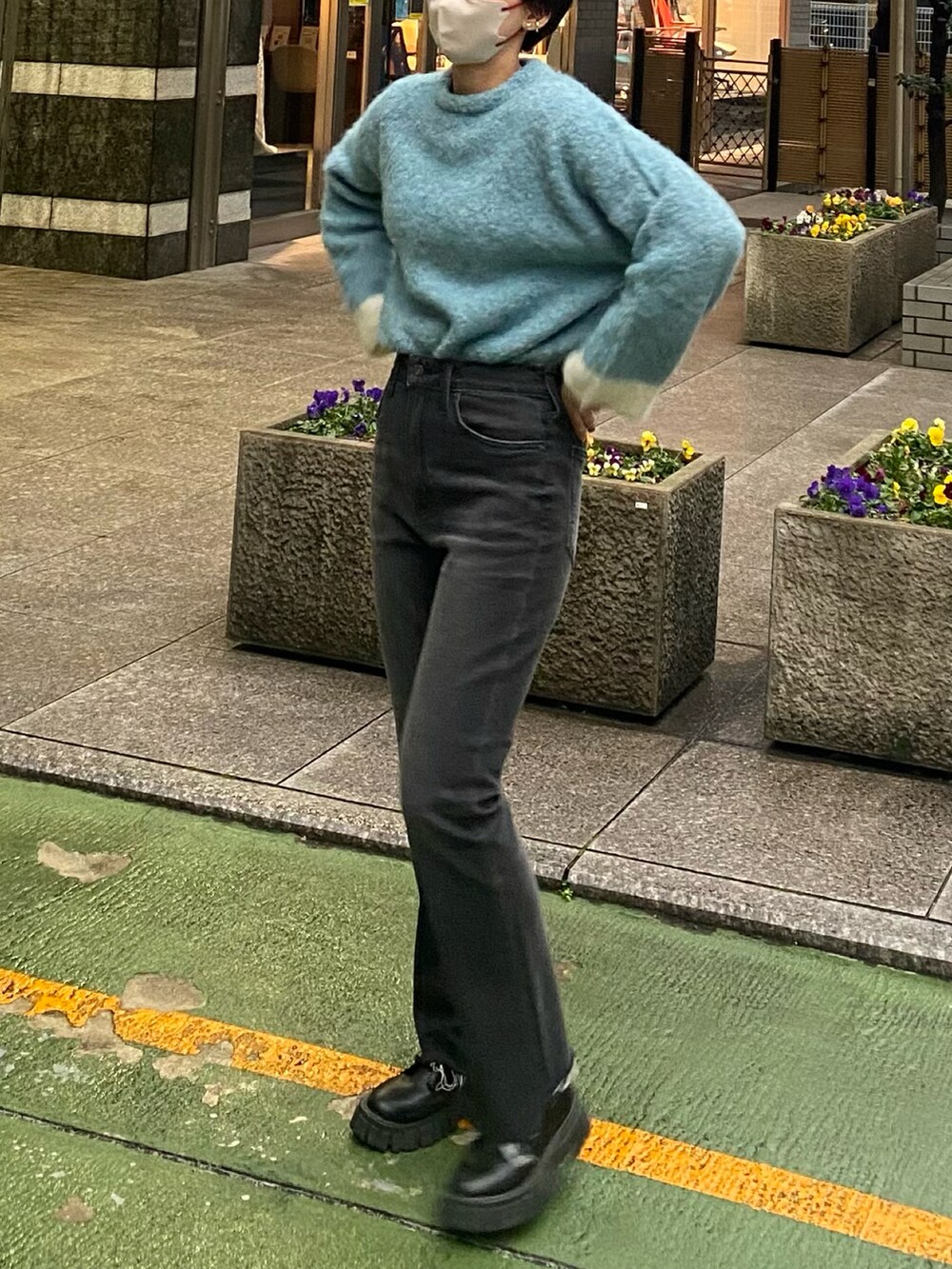 ブルー系のニット/セーター、ブラック系のデニムパンツ、ブラック系のブーツを着用したレディースの冬コーディネートの3枚目の写真