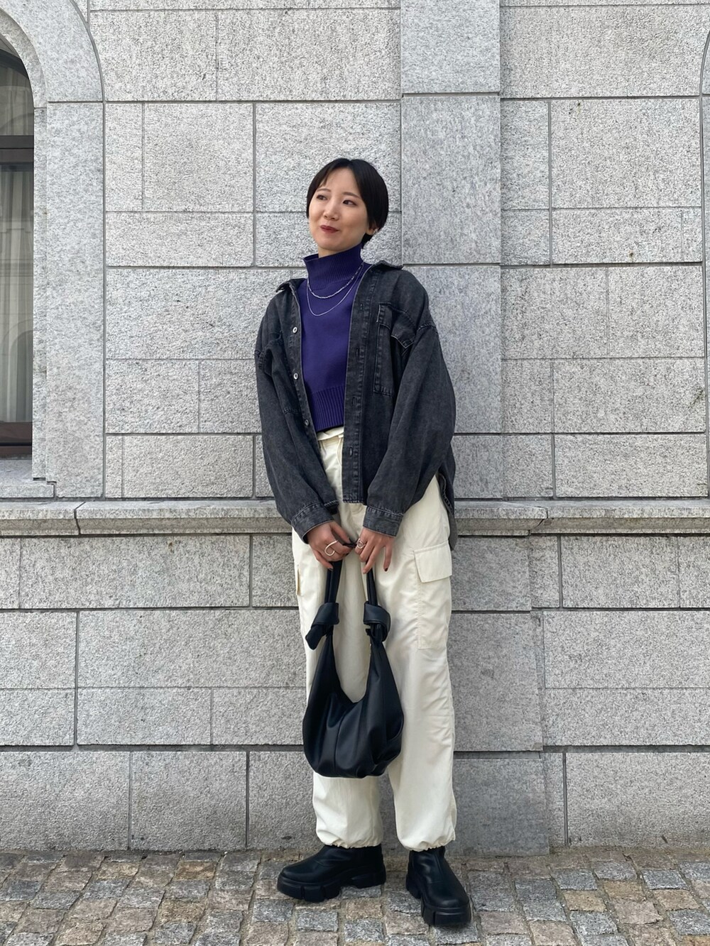 ホワイト系のカーゴパンツ、ブラック系のブーツ、パープル系のニット/セーターを着用したレディースの春コーディネートの2枚目の写真