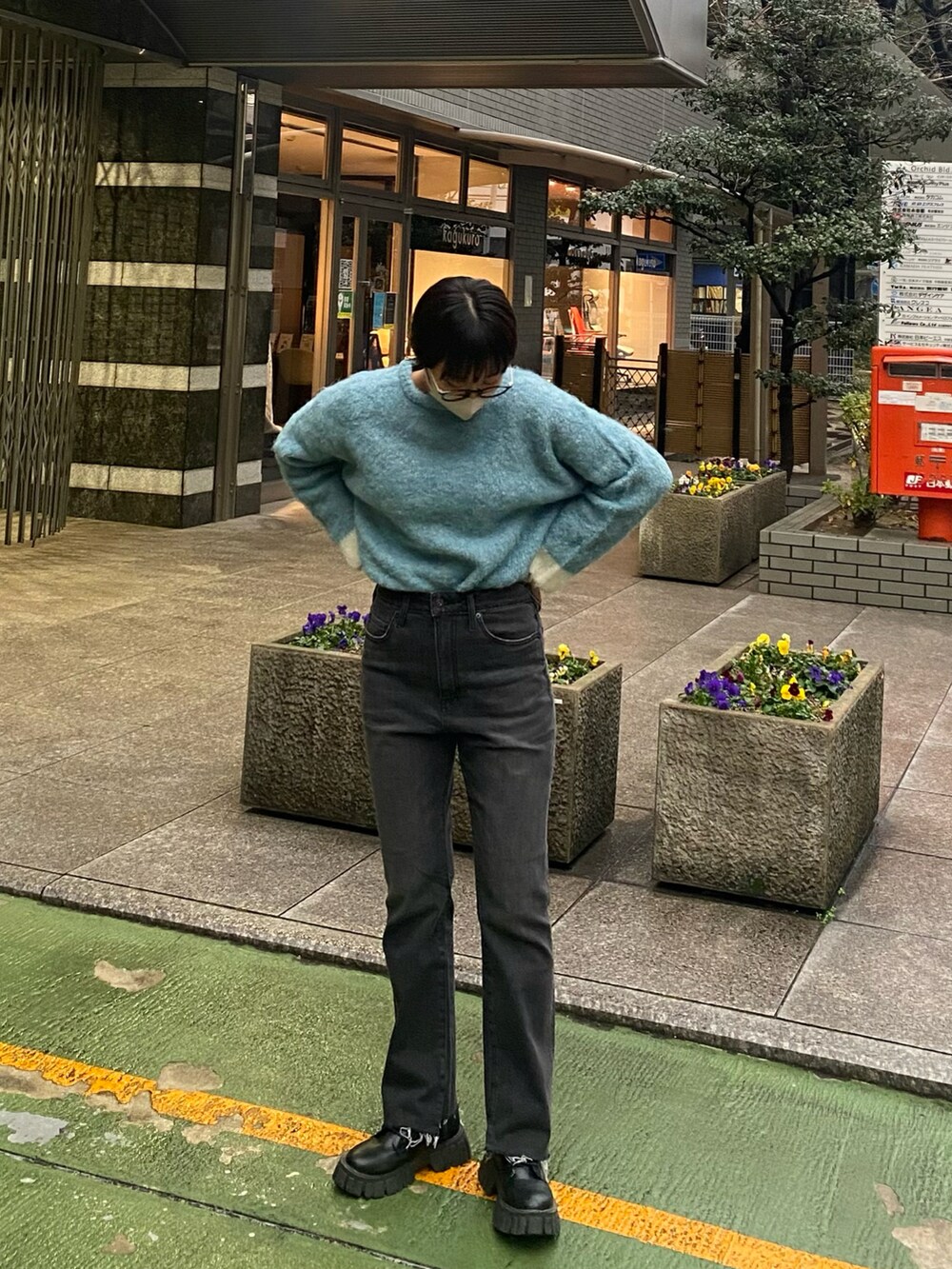 ブルー系のニット/セーター、ブラック系のデニムパンツ、ブラック系のブーツを着用したレディースの冬コーディネートの2枚目の写真