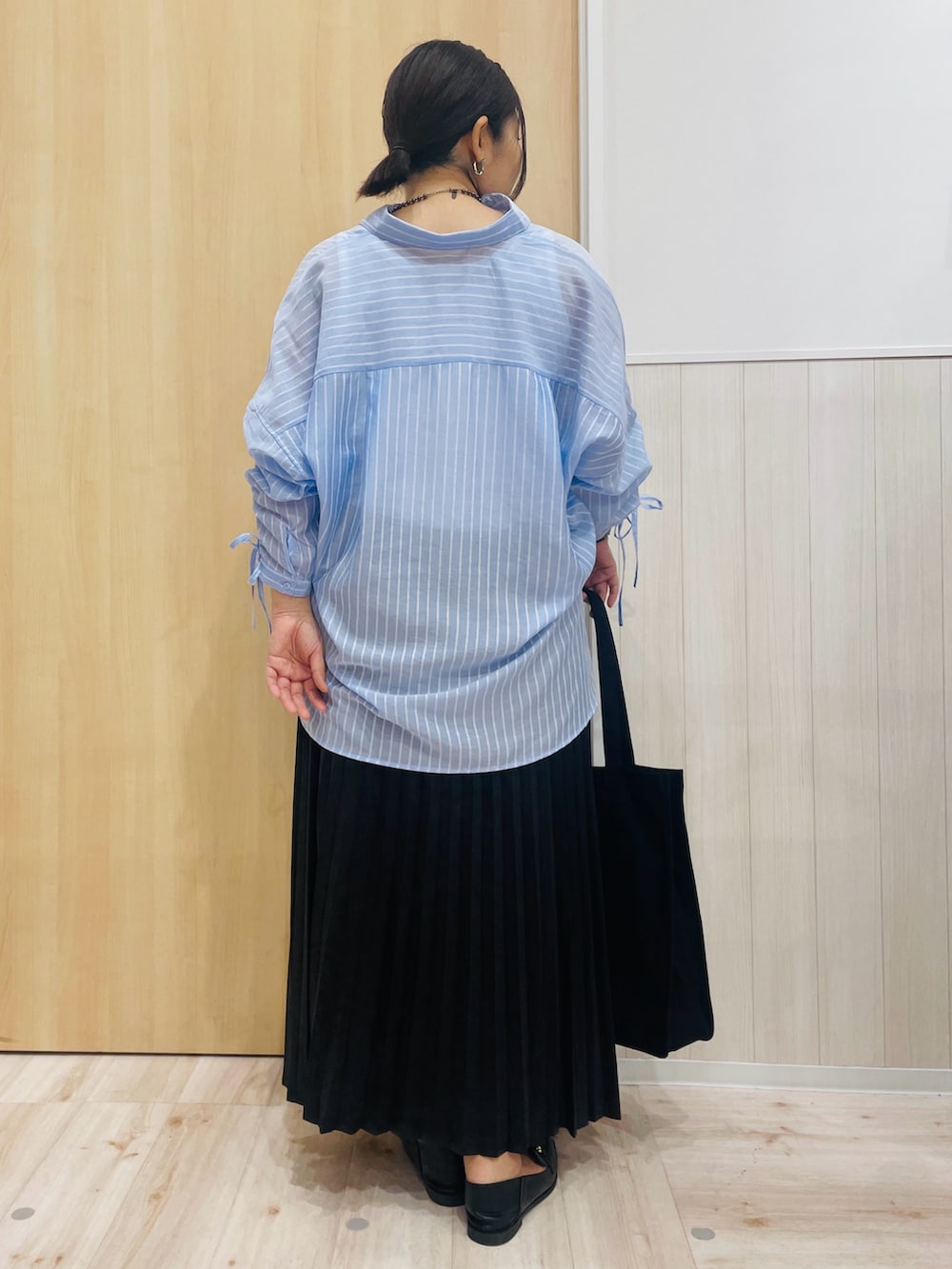 ブルー系のシャツ/ブラウス、ブラック系のその他シューズ、ブラック系のトートバッグを着用したレディースの秋コーディネートの3枚目の写真