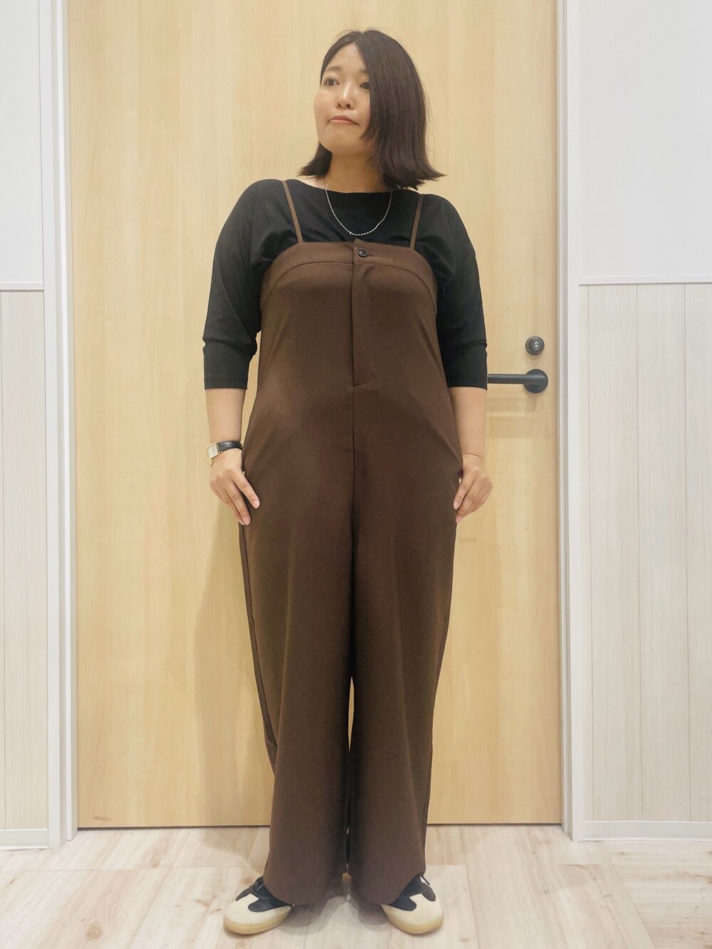 ブラウン系のサロペット/オーバーオール、ブラック系のTシャツ/カットソー、ベージュ系のシャツ/ブラウスを着用したレディースの秋コーディネートの5枚目の写真