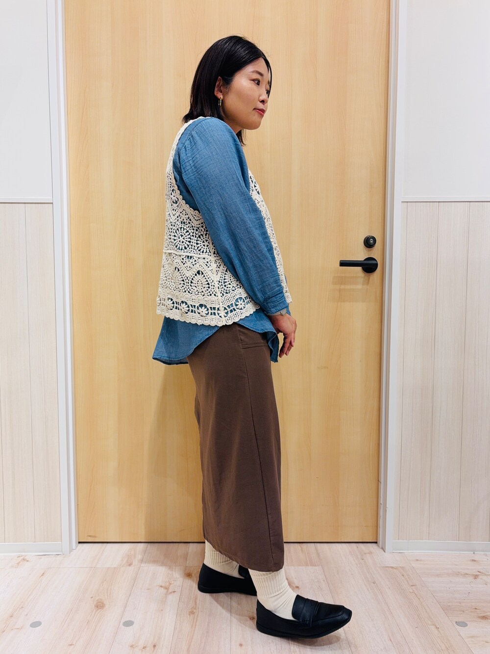ブルー系のシャツ/ブラウス、ブラウン系のスカート、ブラック系のパンプスを着用したレディースの秋コーディネートの2枚目の写真