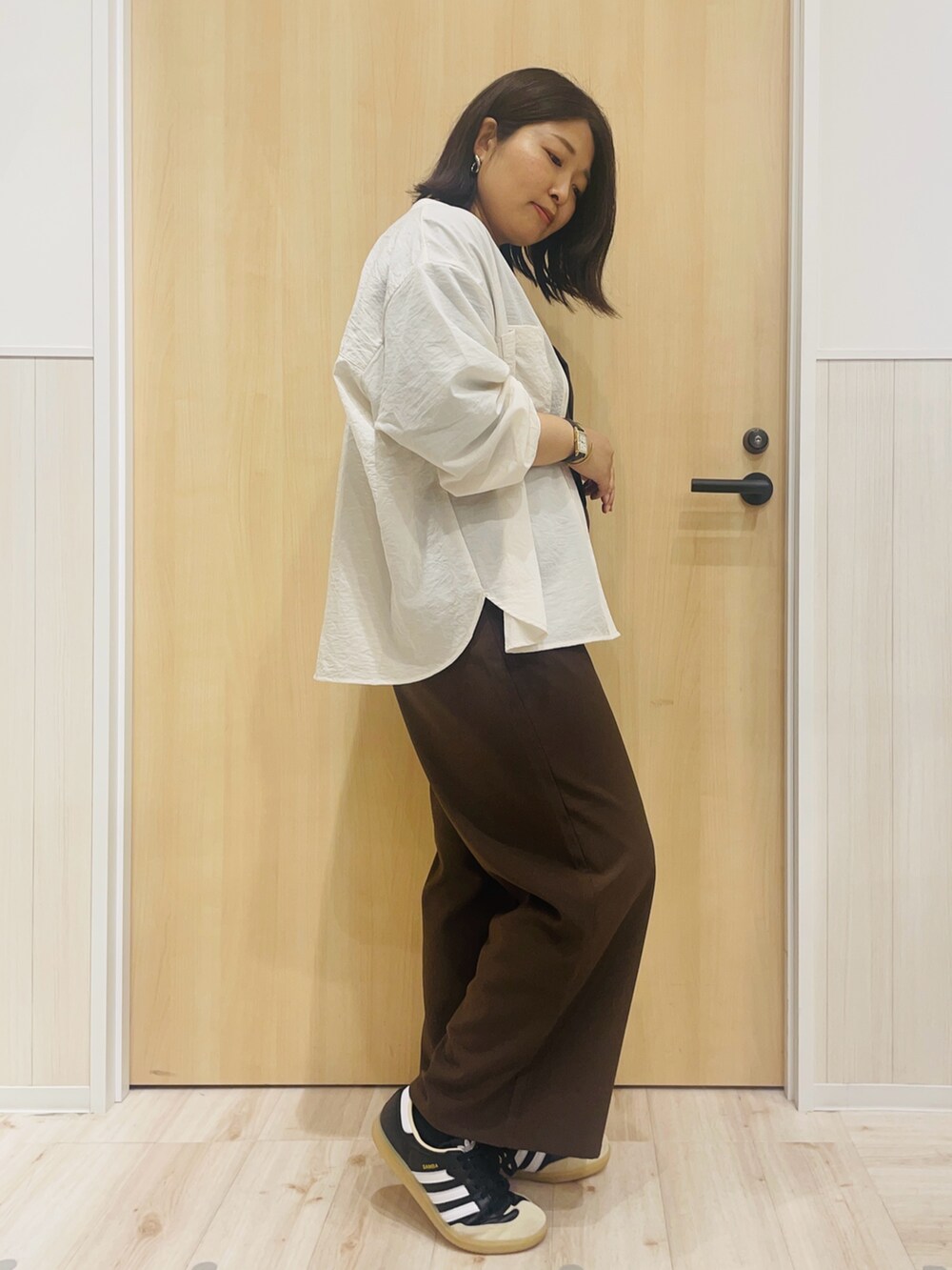 ブラウン系のサロペット/オーバーオール、ブラック系のTシャツ/カットソー、ベージュ系のシャツ/ブラウスを着用したレディースの秋コーディネートの2枚目の写真