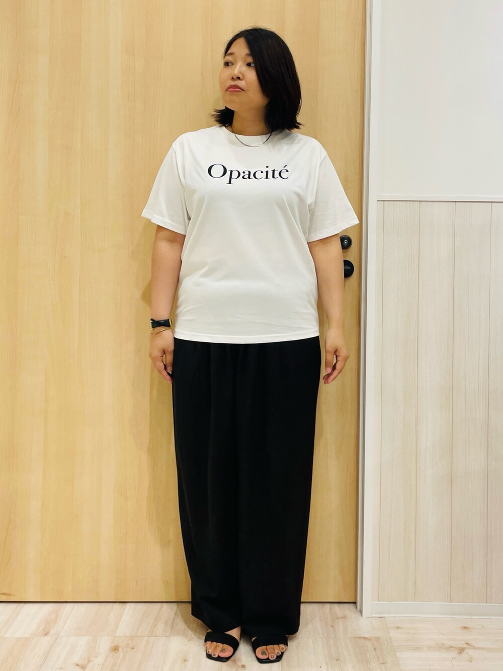 ブラウン系のベスト、ブラック系のその他パンツ、ブラック系のサンダルを着用したレディースの秋コーディネートの4枚目の写真