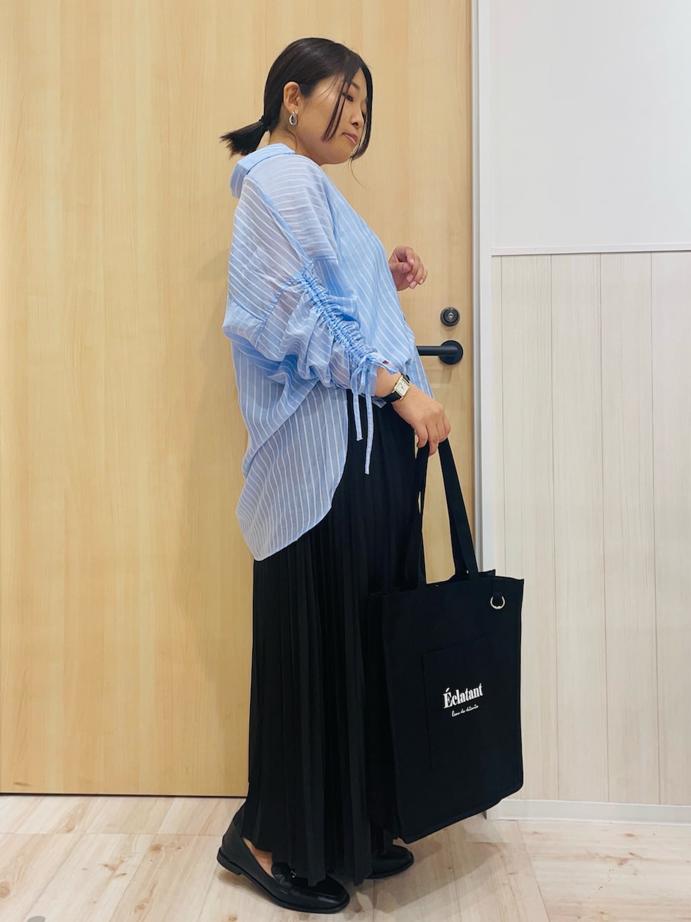 ブルー系のシャツ/ブラウス、ブラック系のその他シューズ、ブラック系のトートバッグを着用したレディースの秋コーディネートの2枚目の写真