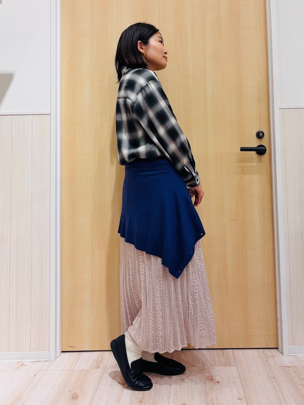 グレー系のシャツ/ブラウス、ブルー系のカーディガン/ボレロ、ベージュ系のスカートを着用したレディースの秋コーディネートの2枚目の写真