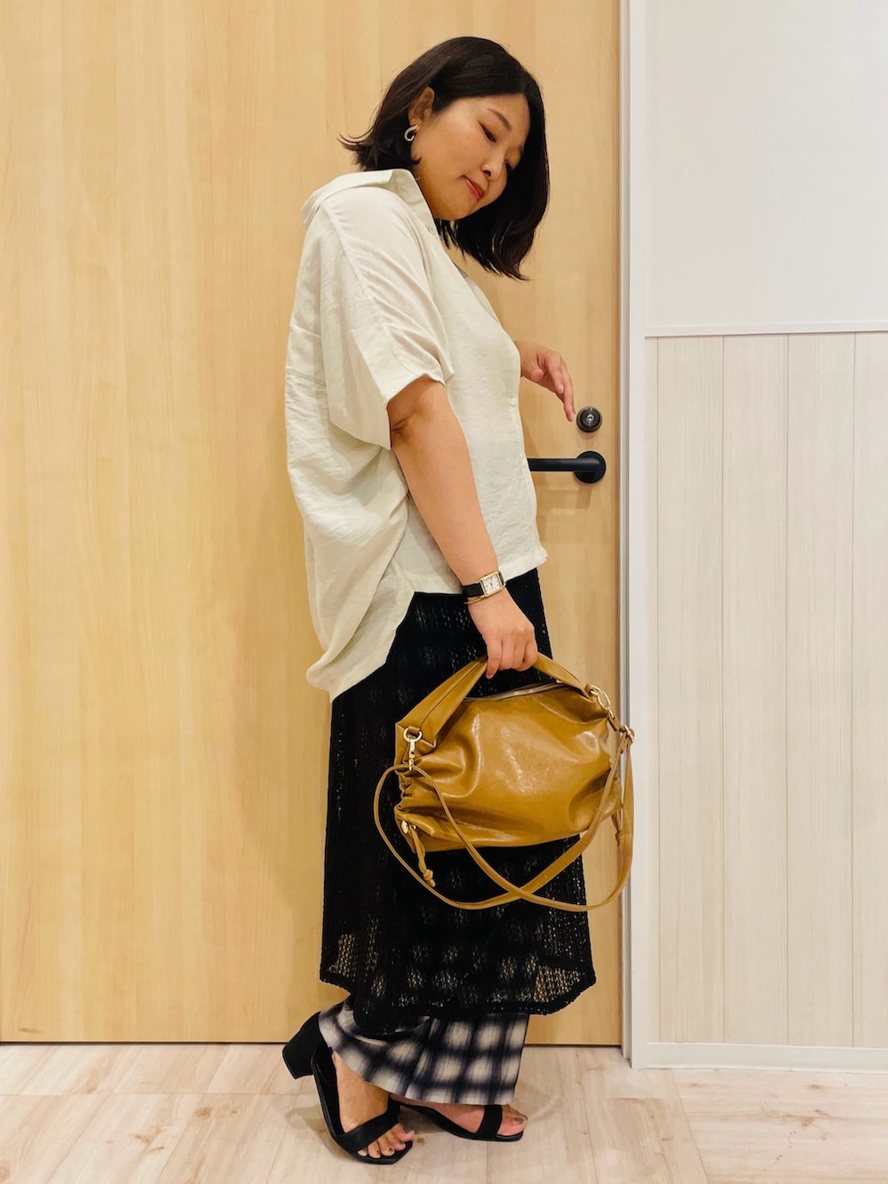 ベージュ系のシャツ/ブラウス、ホワイト系のタンクトップ、ブラック系のスカートを着用したレディースの秋コーディネートの2枚目の写真