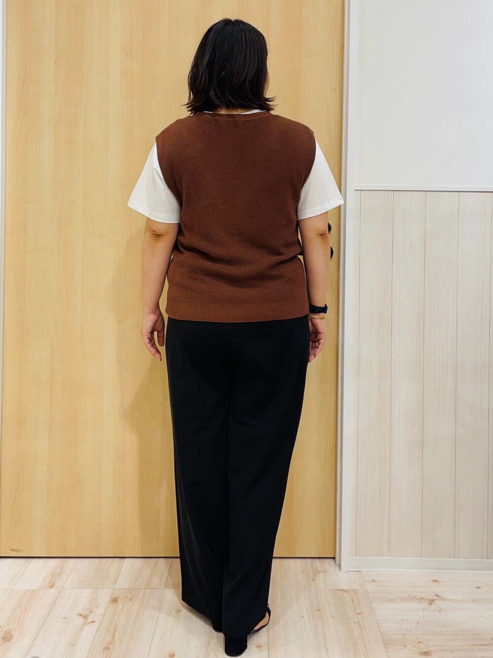 ブラウン系のベスト、ブラック系のその他パンツ、ブラック系のサンダルを着用したレディースの秋コーディネートの3枚目の写真