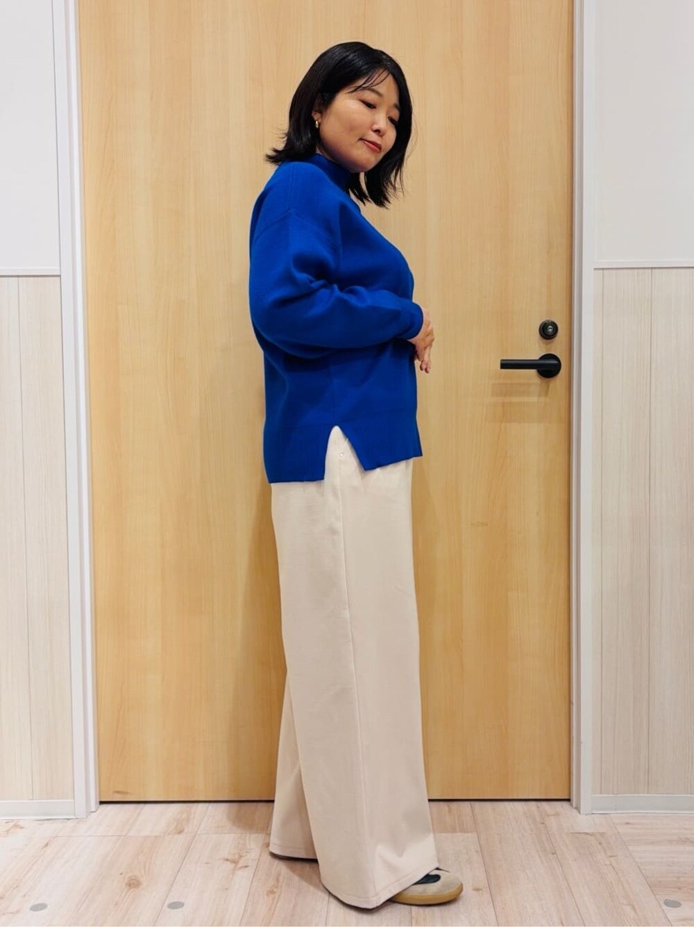 ブルー系のニット/セーター、ホワイト系のその他パンツを着用したレディースの冬コーディネートの2枚目の写真