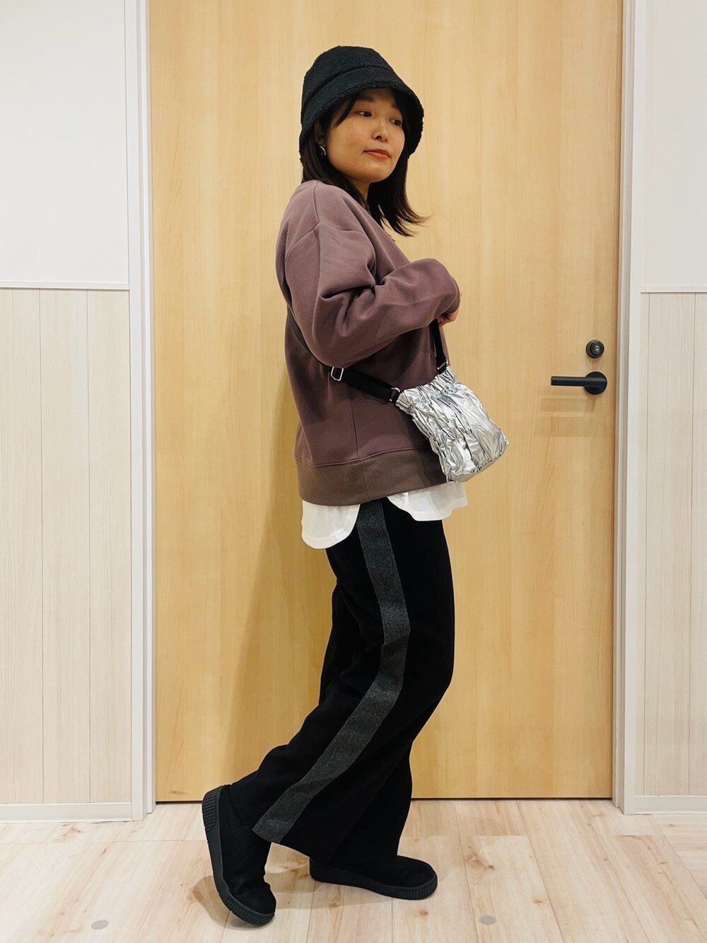 ブラック系のその他パンツ、シルバー系のショルダーバッグ、ブラック系のブーツを着用したレディースの冬コーディネートの2枚目の写真